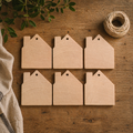 Six wooden house-shaped tags on a wooden surface with twine and leaves.