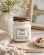 Jar of 'Riverside Smoothie' candle from Fletchers Mill on a table with decorative items.